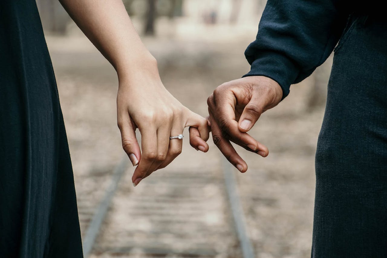 Man and woman holding pinkies man and woman holding pinkies